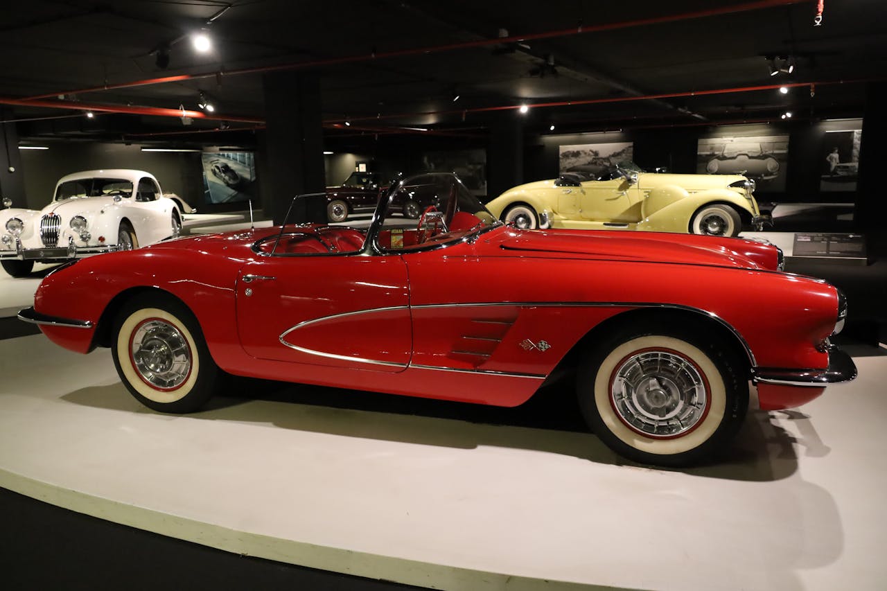 Stunning classic red convertible showcased in an elegant vintage car museum setting.